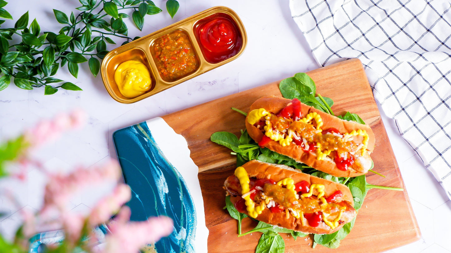Two hot dogs topped with Alexandra’s Pikliz® Spicy Pepper Relish, mustard, and ketchup, showing bold texture and everyday use
