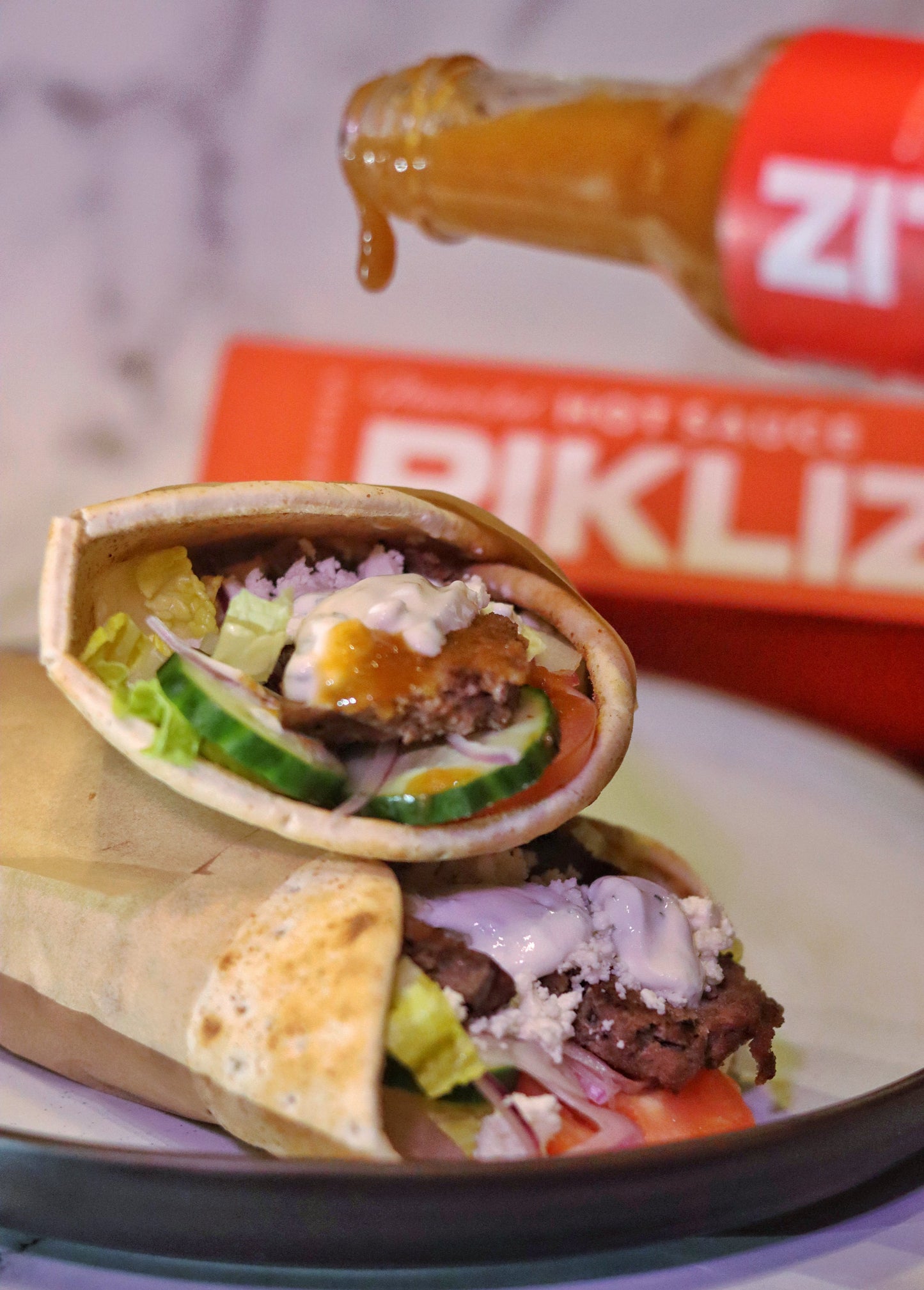 Beef gyros with Alexandra’s Pikliz® Hot Sauce, mint yogurt sauce, lettuce, tomatoes, and pita